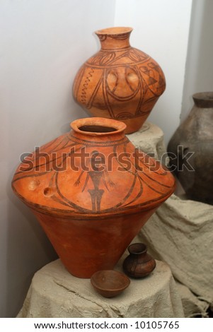 Exposition of very old clay jugs with black ornamental pattern and accessories for carrying