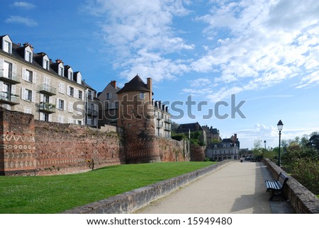 Embankment of Le Mans with ancient Roman boundary wall against the spring sky and modern dwelling houses