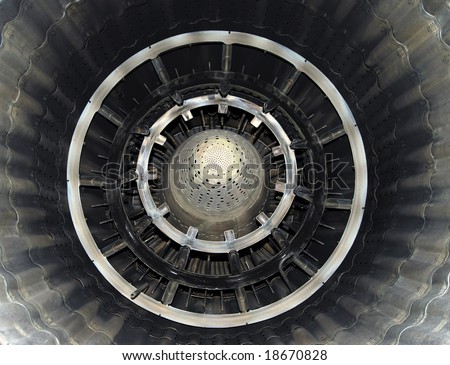 Turbine of airplane from within, close up, metallic blades and circles, shining symmetric patterns