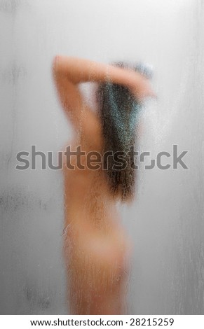 stock photo Nude girl in shower through glass with drops of water