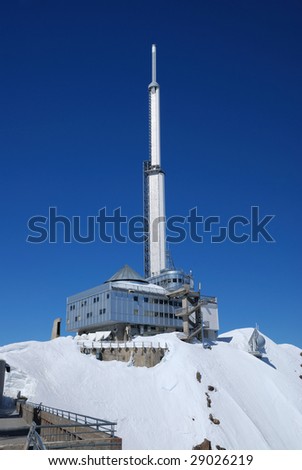 Constructions of weather station on snow slope against blue sky in Pyrenees