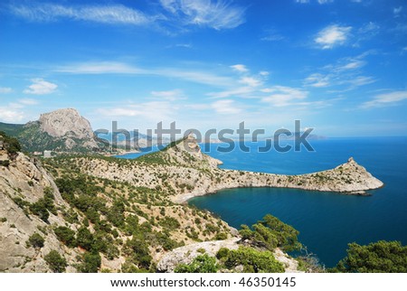 High angle view of a rocky landscape populated with trees by an sea setting. Horizontal shot.