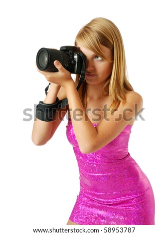 An attractive girl is shooting with DSLR. She is wearing a rosy strapless dress. Her sexy body is beautifully accentuated with the shining dress outlines the figure.