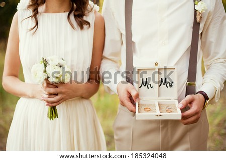 bride and groom with rings and bouquet