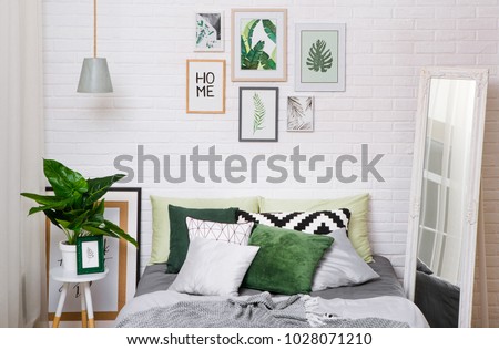 bedroom interior in gray green tones with a ficus mirror curtain of a chandelier and pictures on a white wall \
horizontal frame