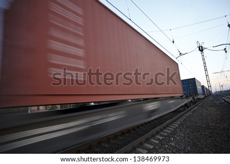 The cargo train moving at great speed by station