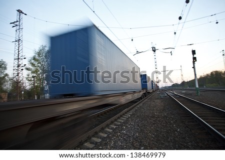 The cargo train moving at great speed by station