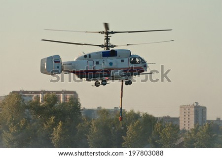 MOSCOW, RUSSIA - AUG 6, 2011: Russian helicopter Kamov Ka-32 Ministry of Emergency Situations ready for takes water from a pond for fire extinguishing. Aug, 6, 2011 in Moscow, Russia