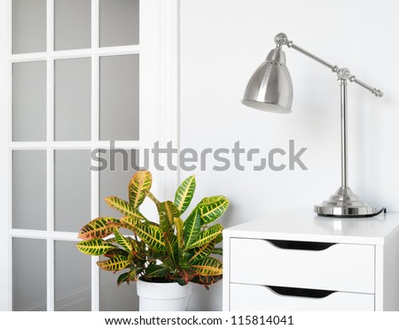 Modern room decor. Green plant, stylish furniture and lighting.
