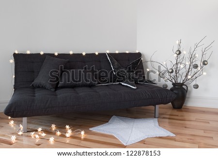 Cozy lights in the living room decorating sofa and tree branches.