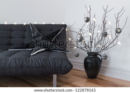 Gray sofa, winter decorations and cozy lights in the living room.