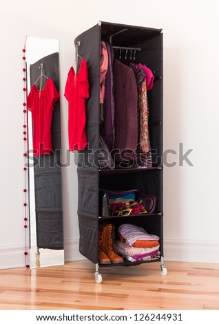 Mobile clothes organizer with red and purple clothing and accessories.