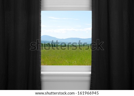 Summer landscape seen through the window with black curtains.