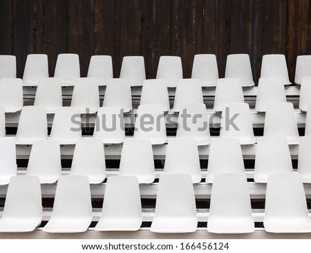 White empty seats in an outdoor venue.