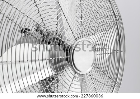 Detail of a modern metal electric fan with shiny blades.