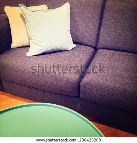 Green coffee table and sofa with cushions. Modern furniture.