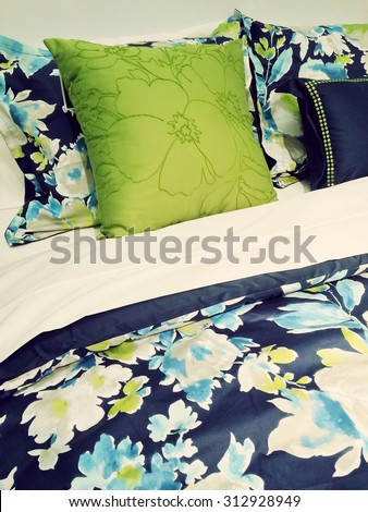 Close-up of a bed. Blue and green bed linen with floral design.