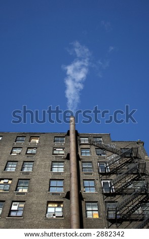 Smoking house. Smoke going out of the chimney of a brick house.