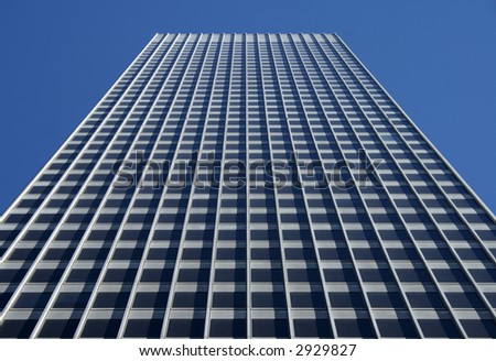 Perspective view of the gray office building against the blue sky.