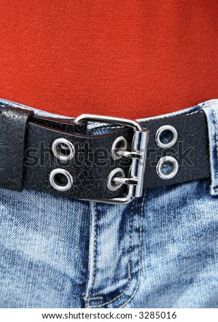 Black leather belt with metal buckle, worn with orange shirt and blue jeans.