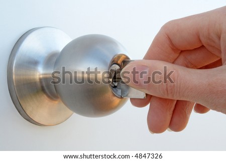 stock photo : Woman's hand unlocking the door with a key.