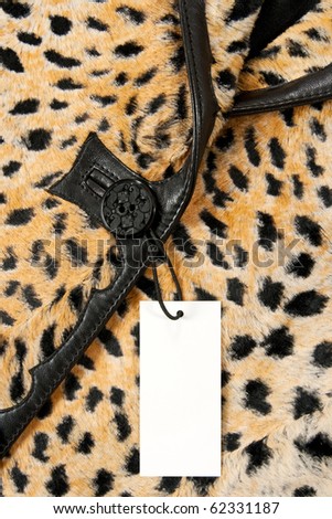 Blank label or price tag attached to a button of a stylish leopard jacket.