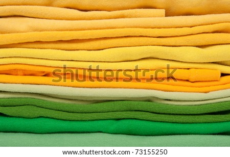 Background of folded joyful green and yellow clothes.