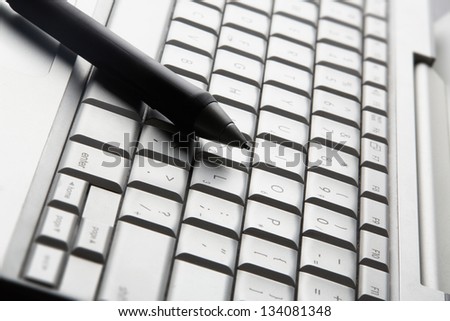 Grip pen on laptop keyboard, close-up