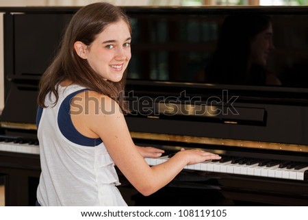 Tween girl playing the piano with hands on keyboard