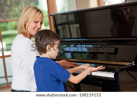 Piano teacher giving lessons to a young boy