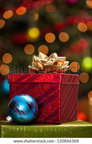 Christmas presents and ornaments under a Christmas tree with defocused lights