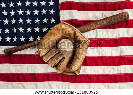 Vintage baseball bat, glove and ball on a vintage American flag