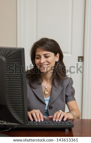 Business woman typing at her home office computer