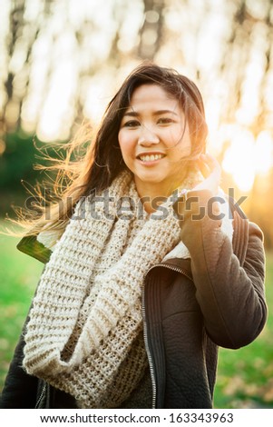 Portrait of a young Asian woman at the park in the late afternoon on an autumn day