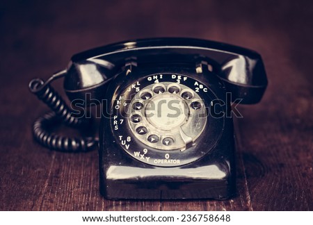 Vintage rotary phone on a rustic farm table with filtered effect