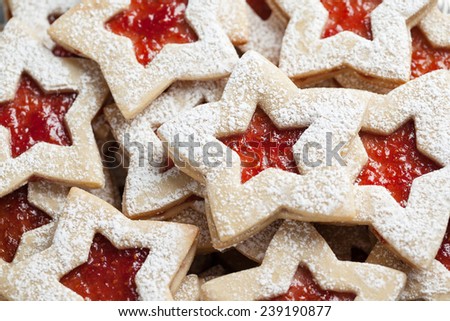 Plate of raspberry jam sandwich sugar Christmas cookies in star shaped cutout