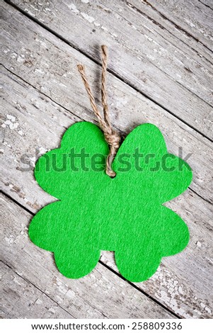 Green felt shamrock cutout on a vintage wooden distressed table for St. Patrick\'s Day