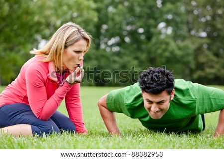 Fitness trainer coaching a trainee doing push ups