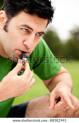 Male fitness coach blowing whistle