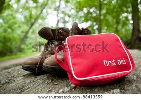 First aid kit and hiking boots in the woods