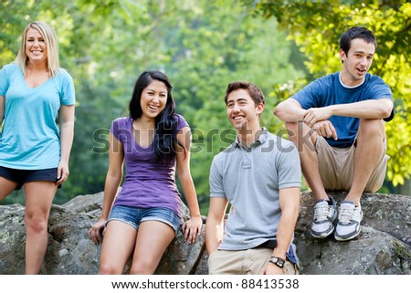 Group of four young casual men and women at the park