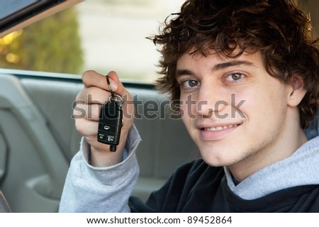 Teen boy who just got his driver\'s license holding keys in the car