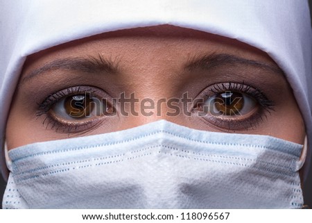 Close-up of female doctor wearing surgical cap and mask