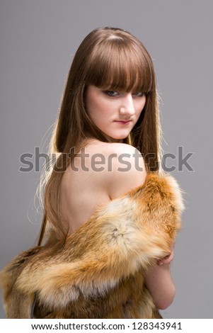 woman wearing a fox fur on a gray background