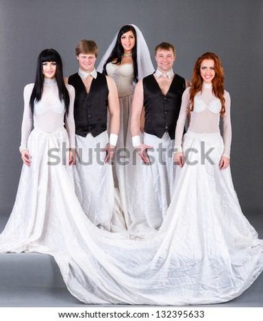 Actors in the wedding dress posing. On a gray background in full length.