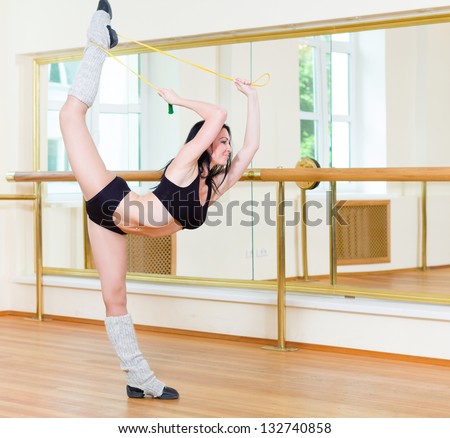 Portrait of young sporty girl doing physical exercise in front of mirror