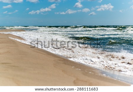 Beautiful beach landscape with cloudy sky and sea with waves. Baltic sea coast.