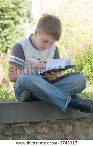 The little boy writes to writing-books