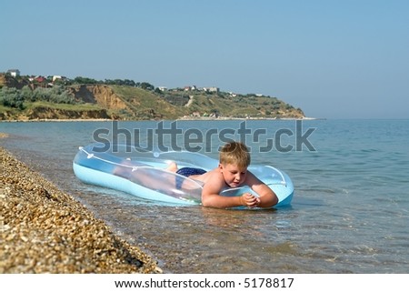 little boy in an inflatable boat on the beach