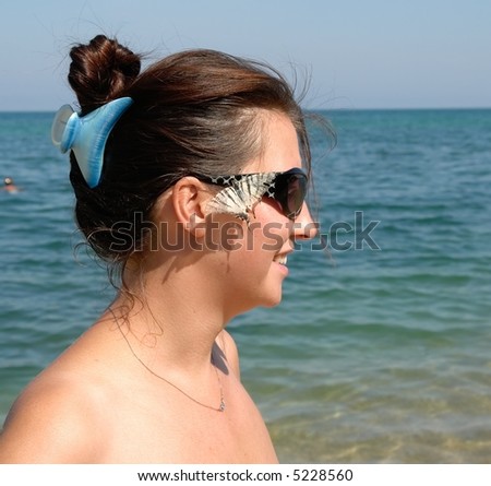 Beautiful Young Woman on the Beach.  live butterfly on the face.
